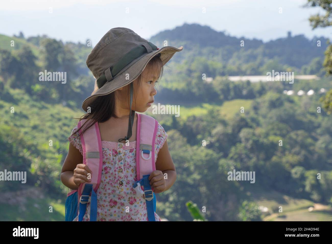 Kleine asiatische Kinder wandern Berg. Kinder-Bergsteiger, die Spaß haben, während sie einen Berg mit einem Rucksack besteigen. Stockfoto