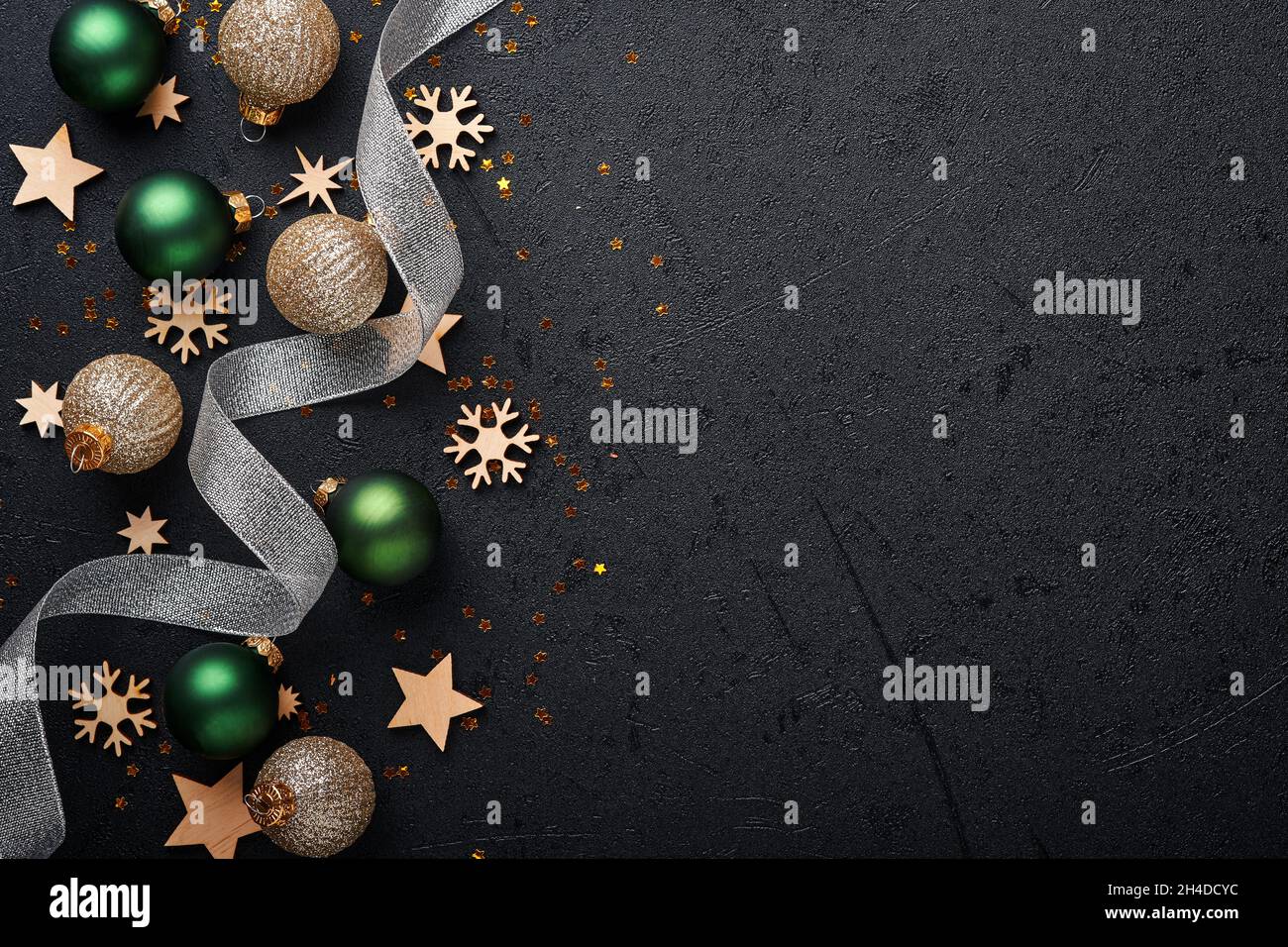 Weihnachtliche goldene, grüne und silberne Kugeln Kugeln dunkelschwarzer Hintergrund. Weihnachtsdekoration. Weihnachtsdekorationen mit goldenen Kugeln. Bordüre. Bis Stockfoto