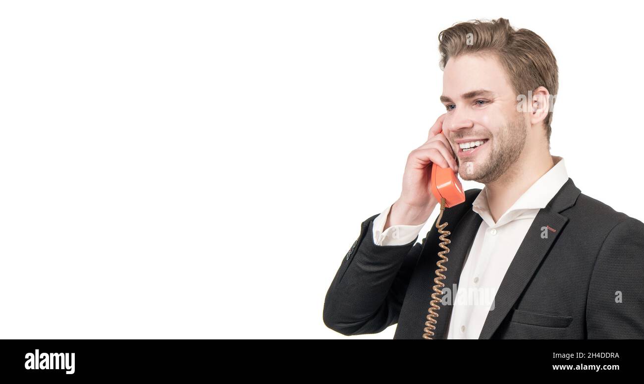 Ein glücklicher Mann-Callcenter-Betreiber ist mit einem altmodischen, altmodischen schnurgebundenen Telefon ausgestattet, das im Retro-Stil eingerichtet ist Stockfoto