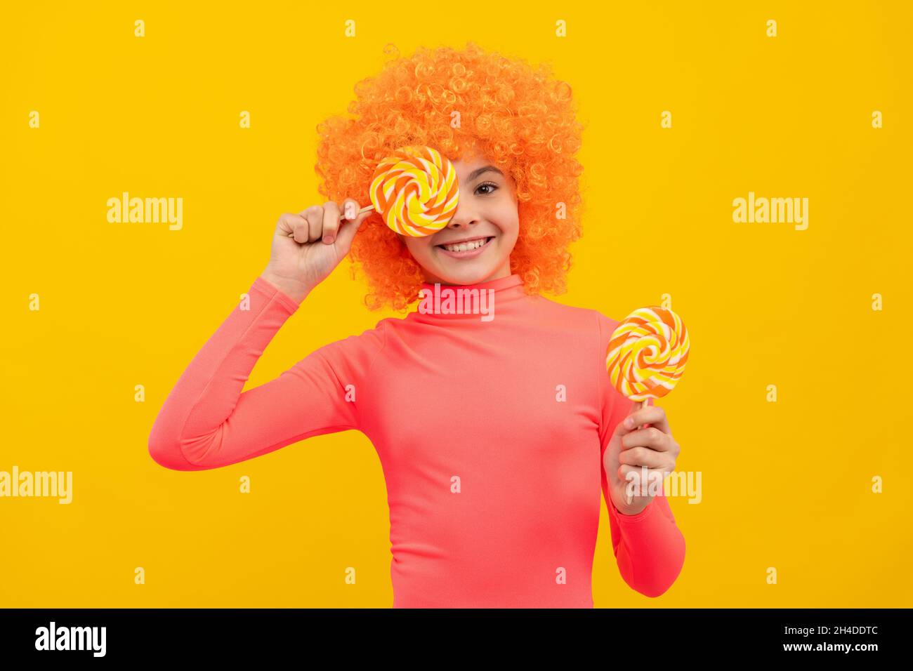 Happy girl Kind mit orangen Haaren in rosa Poloneck haben Spaß halten Lutscher, Mädchenschaft Stockfoto