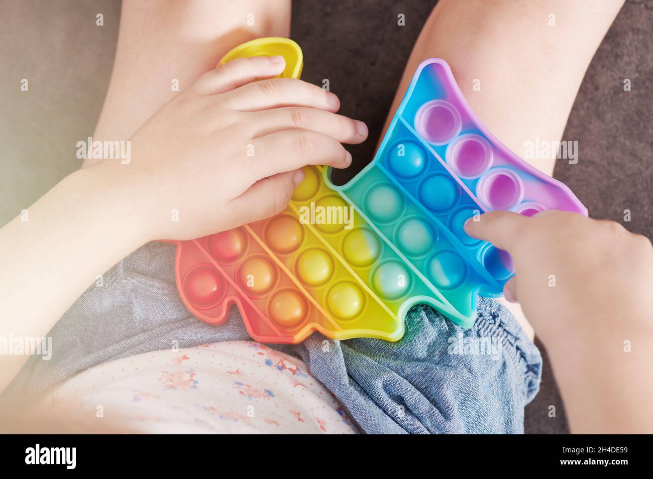 Kleine Kinder spielen popit Nahaufnahme Hände auf Blasen Stockfoto