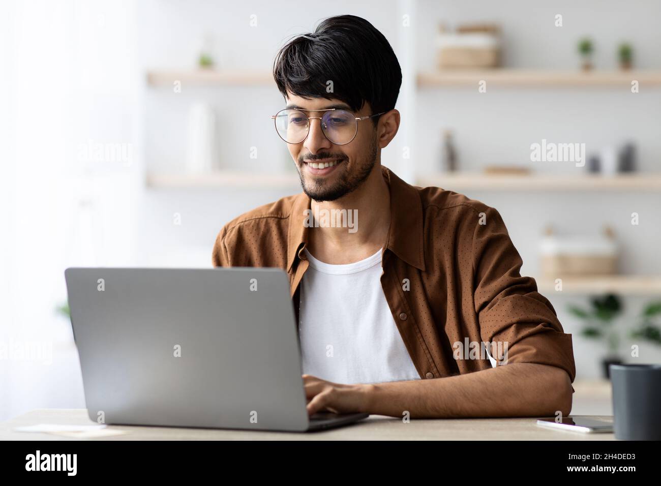 Glücklicher Mann aus dem Nahen Osten, der im Büro arbeitet Stockfoto