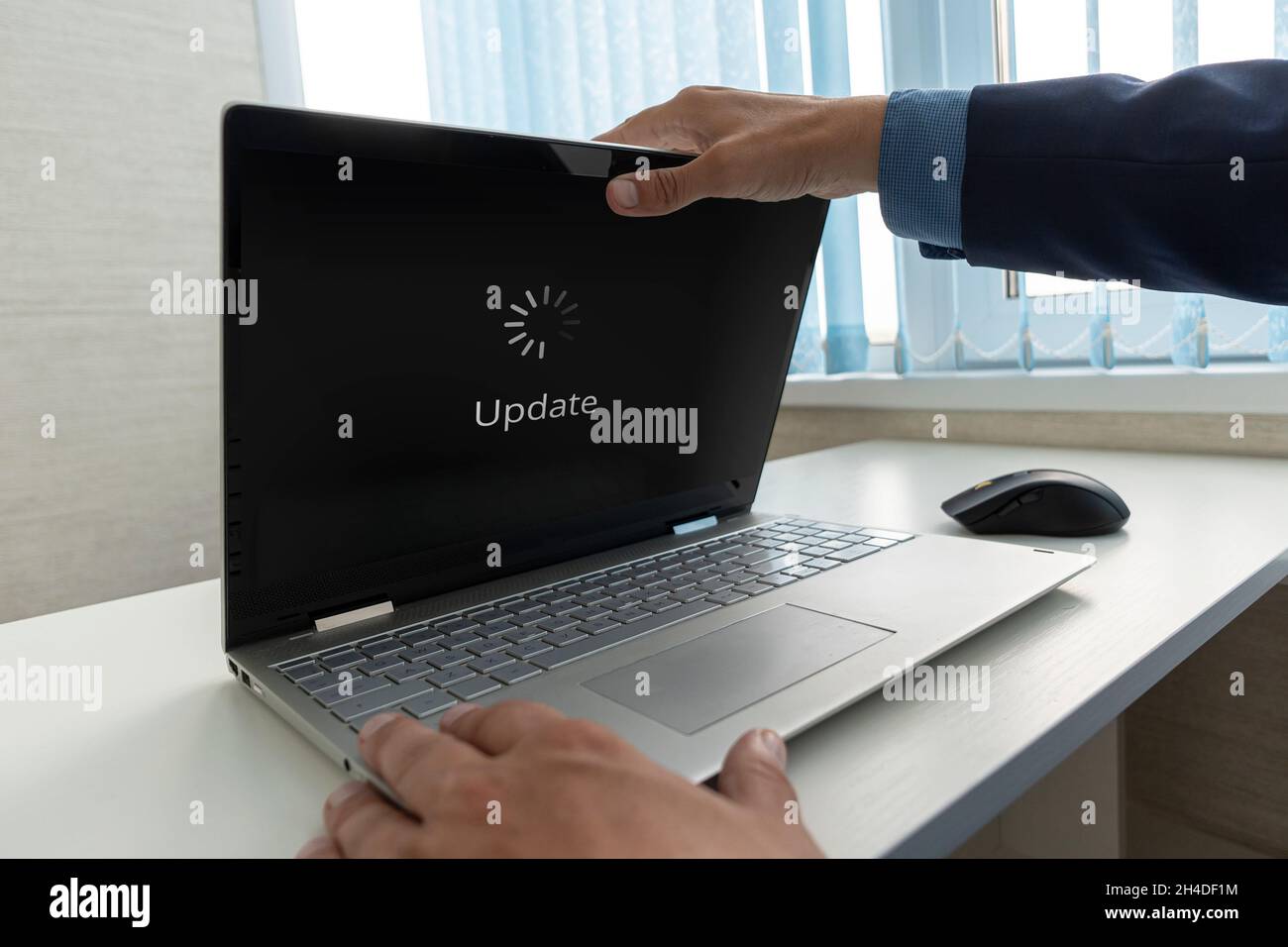 Updating Software Technology Upgrade Concept. Ein Geschäftsmann öffnet ein modernes Ultrabook, auf dem das Betriebssystem aktualisiert wird. Stockfoto