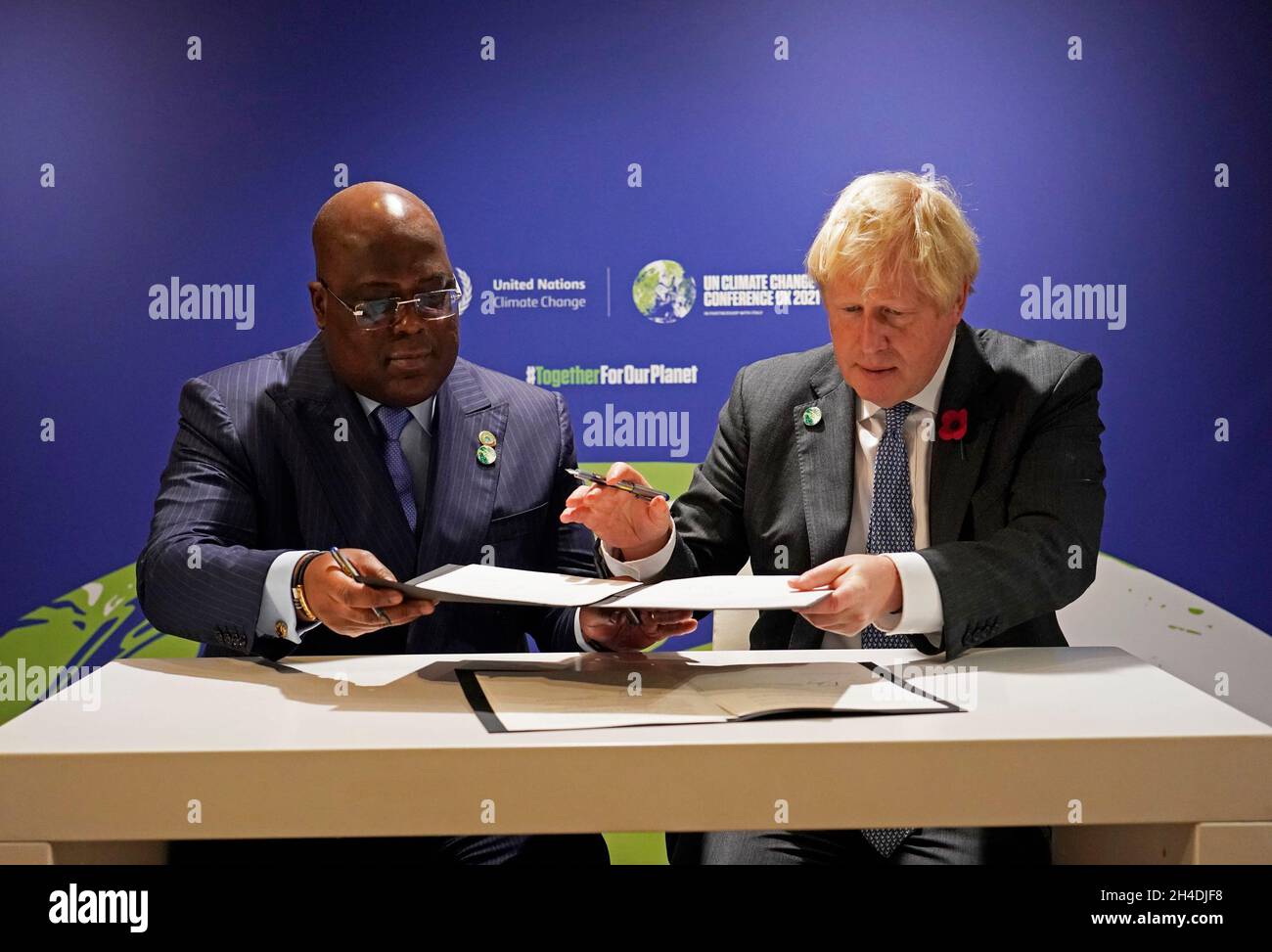 Premierminister Boris Johnson (rechts) unterzeichnet ein Buch mit dem Präsidenten der Demokratischen Republik Kongo und dem Vorsitzenden der Afrikanischen Union, Felix Tshisekedi, während eines bilateralen Treffens beim Cop26-Gipfel auf dem Scottish Event Campus (SEC) in Glasgow. Bilddatum: Dienstag, 2. November 2021. Stockfoto