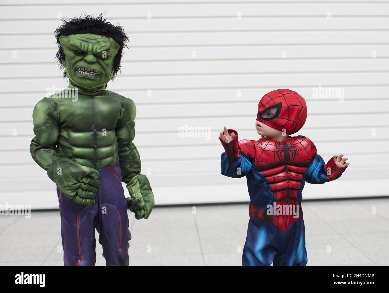 Spiderman, 18 Monate alter Logan Stribbling, sieht sich während der London Super Comic Con am Samstag, den 20. Februar, im London Excel verängstigt über seinen Freund Incredible Hulk, den vierjährigen Zachary Vaughan. Stockfoto