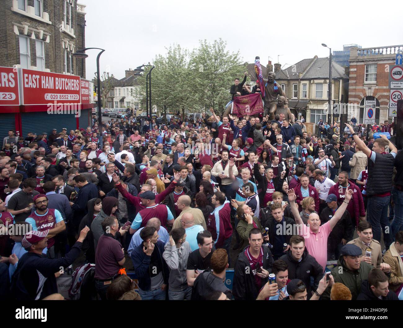 West Ham United-Fans übernehmen die Bobby Moore-Statue und blockieren die Barking Road vor dem Boleyn Ground, im Osten Londons, vor dem letzten Barclays Premier League-Spiel, das im Upton Park gespielt wurde, bevor die Hammers ins Olympiastadion ziehen. Stockfoto