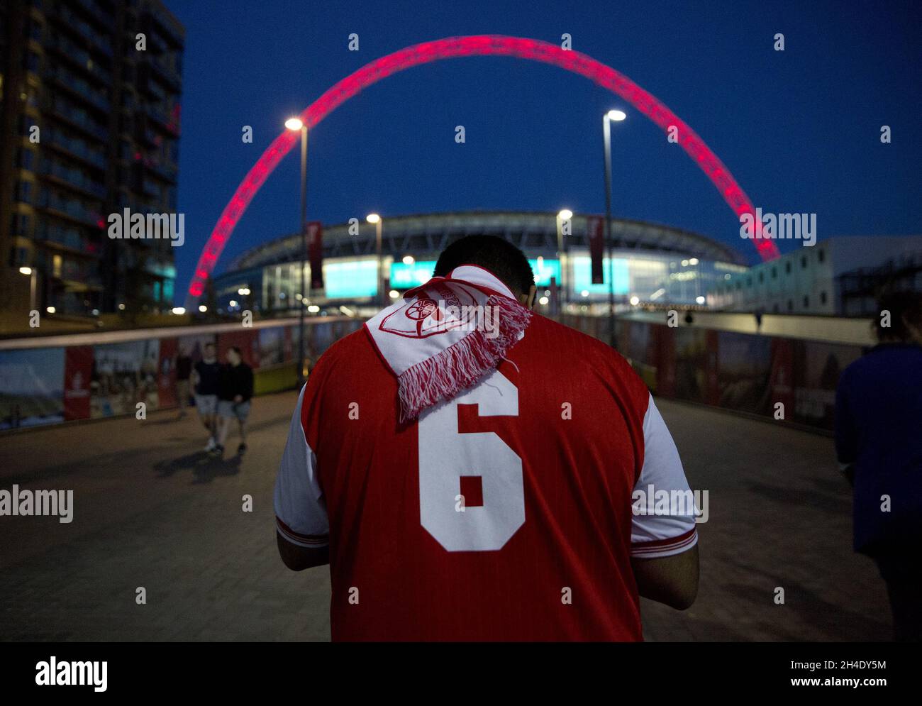 Ein Fußballfan von Arsenal steht draußen, während der Bogen des Wembley-Stadions nach dem Sieg von Arsenal gegen Chelsea beim FA Cup-Finale in London, England, rot leuchtet. Bild datiert: Samstag, 27. Mai 2017. Bildnachweis sollte lauten: Isabel Infantes / EMPICS Entertainment. Stockfoto