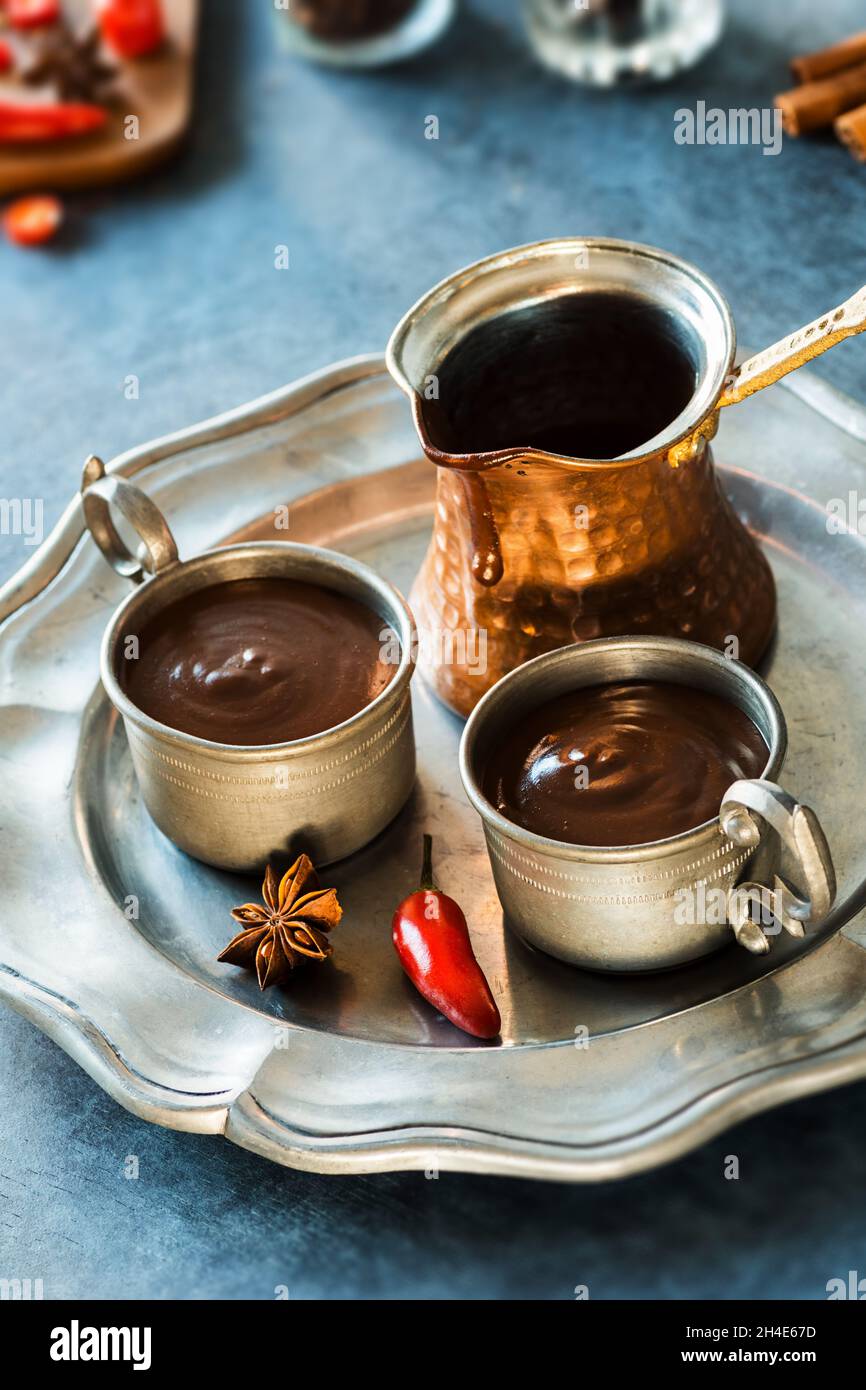 Zwei Tassen scharfe mexikanische oder spanische dicke heiße Schokolade mit Chiles und Zutaten Stockfoto