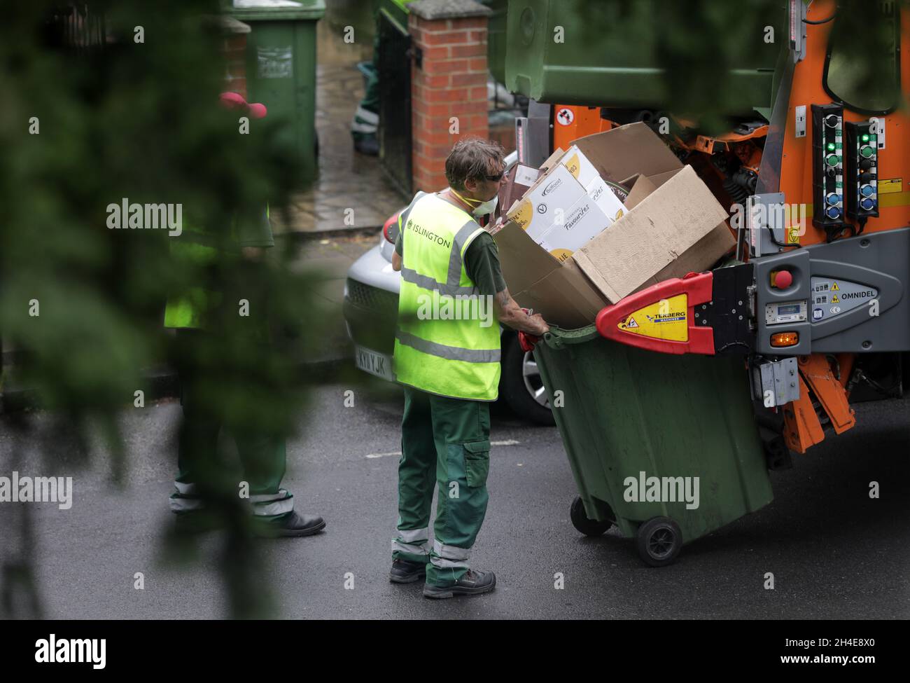 Ein Müllsammler des Islington council, der eine Gesichtsmaske trägt, löscht die Recyclingbehälter von den Anwohnern im Norden Londons. Bilddatum: Donnerstag, 11. Juni 2020. Stockfoto