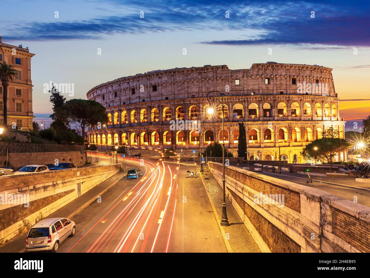 Schöne Aussicht auf das Kolosseum und eine Straße in der Nähe bei Sonnenuntergang, Rom, Italien Stockfoto