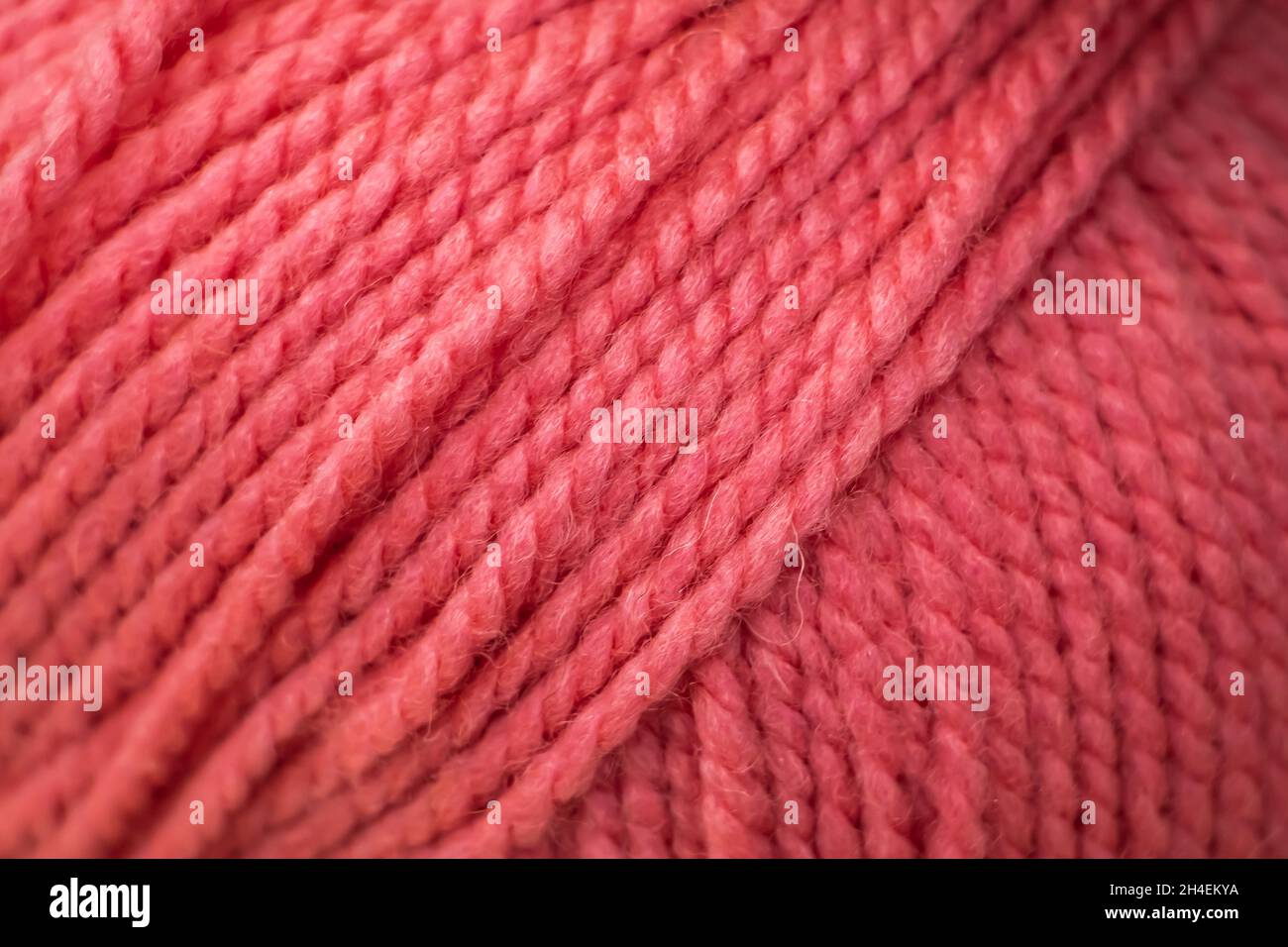 Textur aus rosa flauschigen Wollfäden zum Stricken in Nahaufnahme. Stockfoto