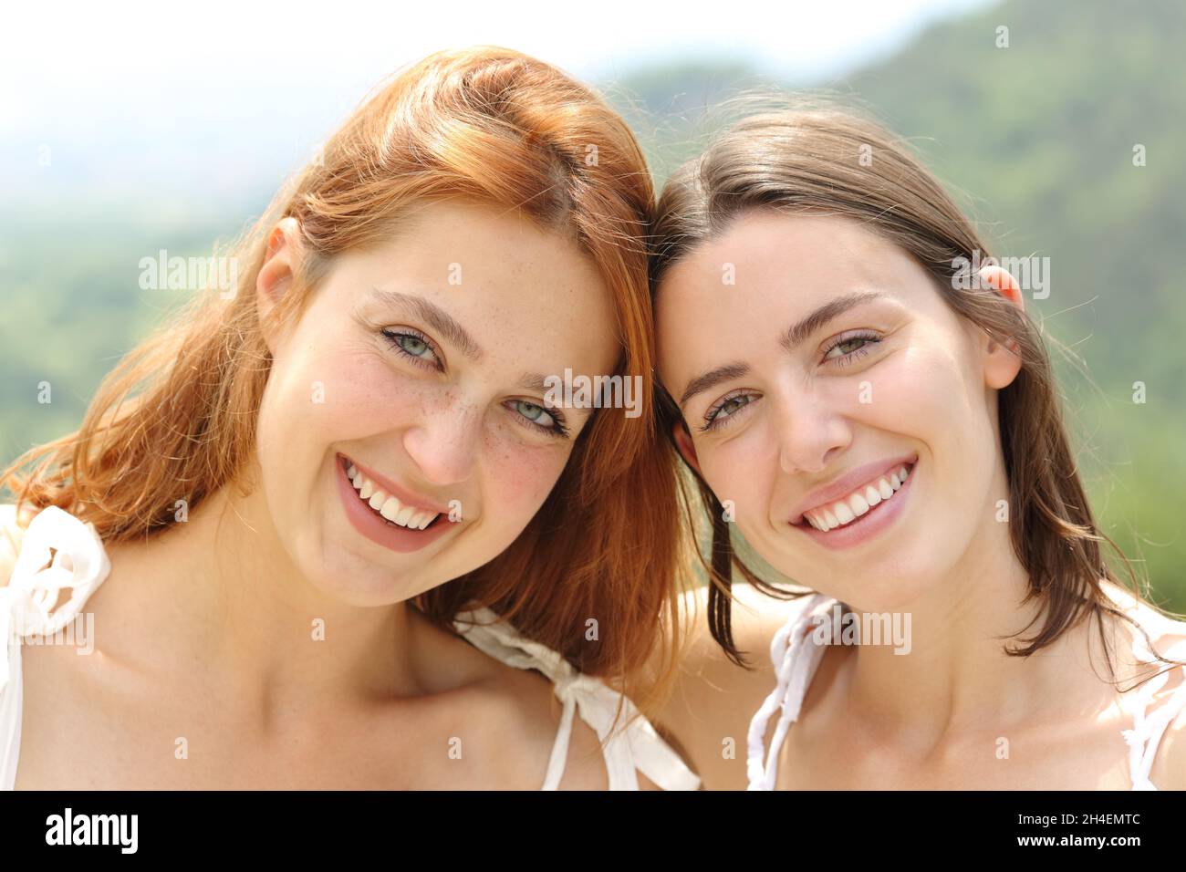 Vorderansicht Porträt von zwei glücklichen Freunden, die lächelnd auf die Kamera blicken Stockfoto