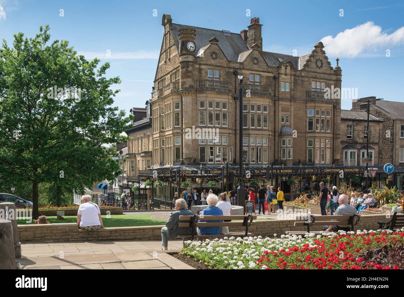 Harrogate Yorkshire, Blick im Sommer auf Menschen, die sich in den Cenotaph Gardens entspannen und auf Bettys Tea Rooms und im Zentrum von Harrogate, Großbritannien, blicken Stockfoto