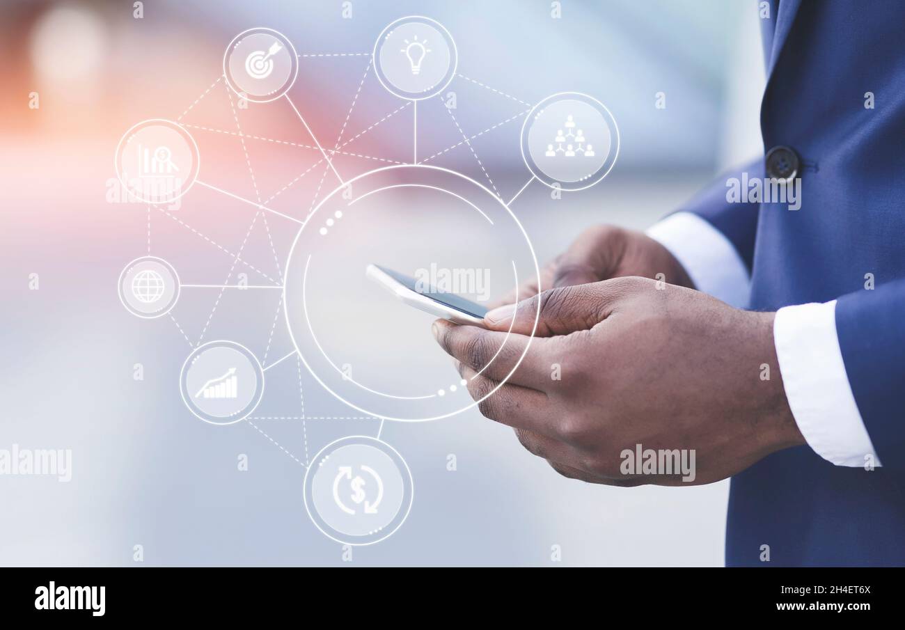 Hände von Millennial african american Geschäftsmann in Anzug tippen auf dem Smartphone, doppelte Belichtung mit Icons Idee Stockfoto