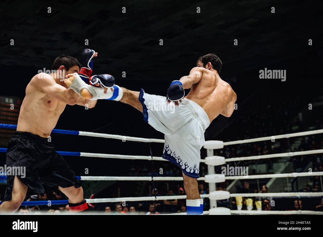 MMA Fighter tritt seinen Gegner mit den Füßen in den Kopf Stockfoto