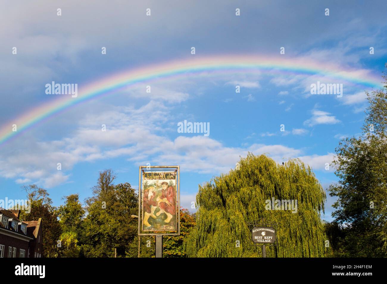 Voller Regenbogen am Himmel über dem Dorfschild. High Street, Chalfont St Giles, Buckinghamshire, England, Großbritannien, Großbritannien Stockfoto