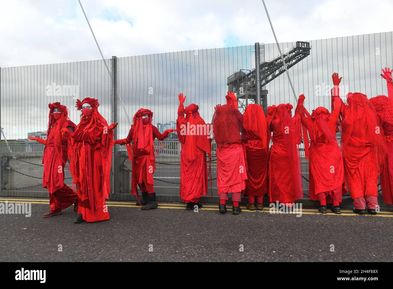 Glasgow, Schottland, Großbritannien, November 02 2021. Extinction Rebellion rot umarmte Demonstranten reisen in einer Prozession durch die Stadt zu den COP 26 Barrikaden, hinter denen sich die Staats- und Regierungschefs der Welt versammeln, um ihre Reaktion auf den Klimawandel zu diskutieren Stockfoto