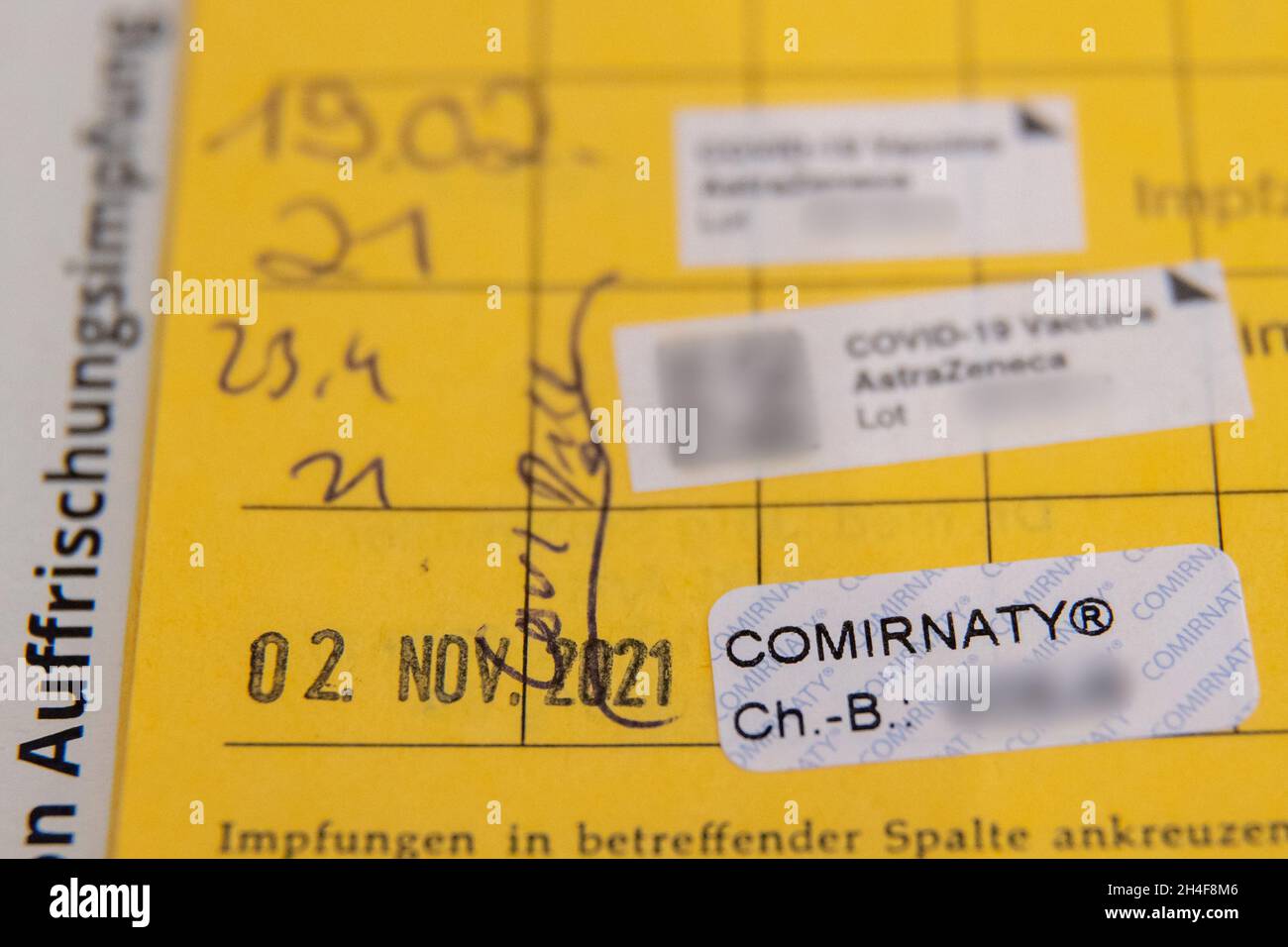02. November 2021, Bayern, Erlangen: Der dritte Aufkleber der Impfung gegen Covid-19 steht in einem Impfbuch eines älteren Mannes nach seiner Auffrischungsimpfung in einem temporären mobilen Impfzentrum. In Bayern. Das bayerische Impfzentrum hat nach wie vor mobile Teams in Erlangen, Deutschland. Termine sind für Personen ab 12 Jahren ohne Anmeldung möglich. Impfstoffe von BioNTech/Pfizer und Johnson & Johnson werden bei allen Terminen angeboten. Foto: Daniel Karmann/dpa - ACHTUNG: Die Chargennummern des Impfstoffs sind aus rechtlichen Gründen verpixelt Stockfoto