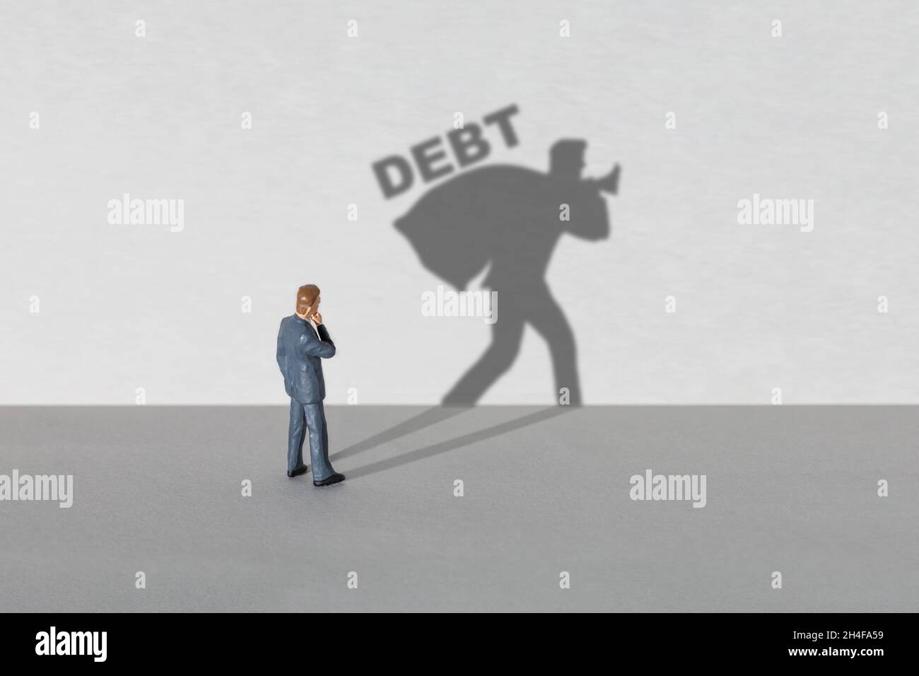 Schulden Geschäftsmann. Geschäftsmann denkt, aber der Schatten zeigt Schulden. Stockfoto