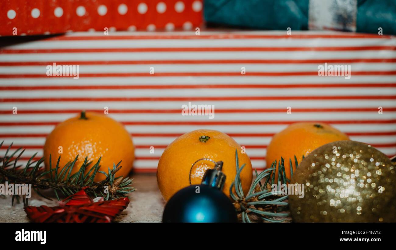 Weihnachtskarte. Weihnachtliche Bordüre mit Kopierraum. Roter Linienhintergrund. Im Vordergrund Mandarinen, Fichtennadeln und glitzernde Weihnachten Stockfoto