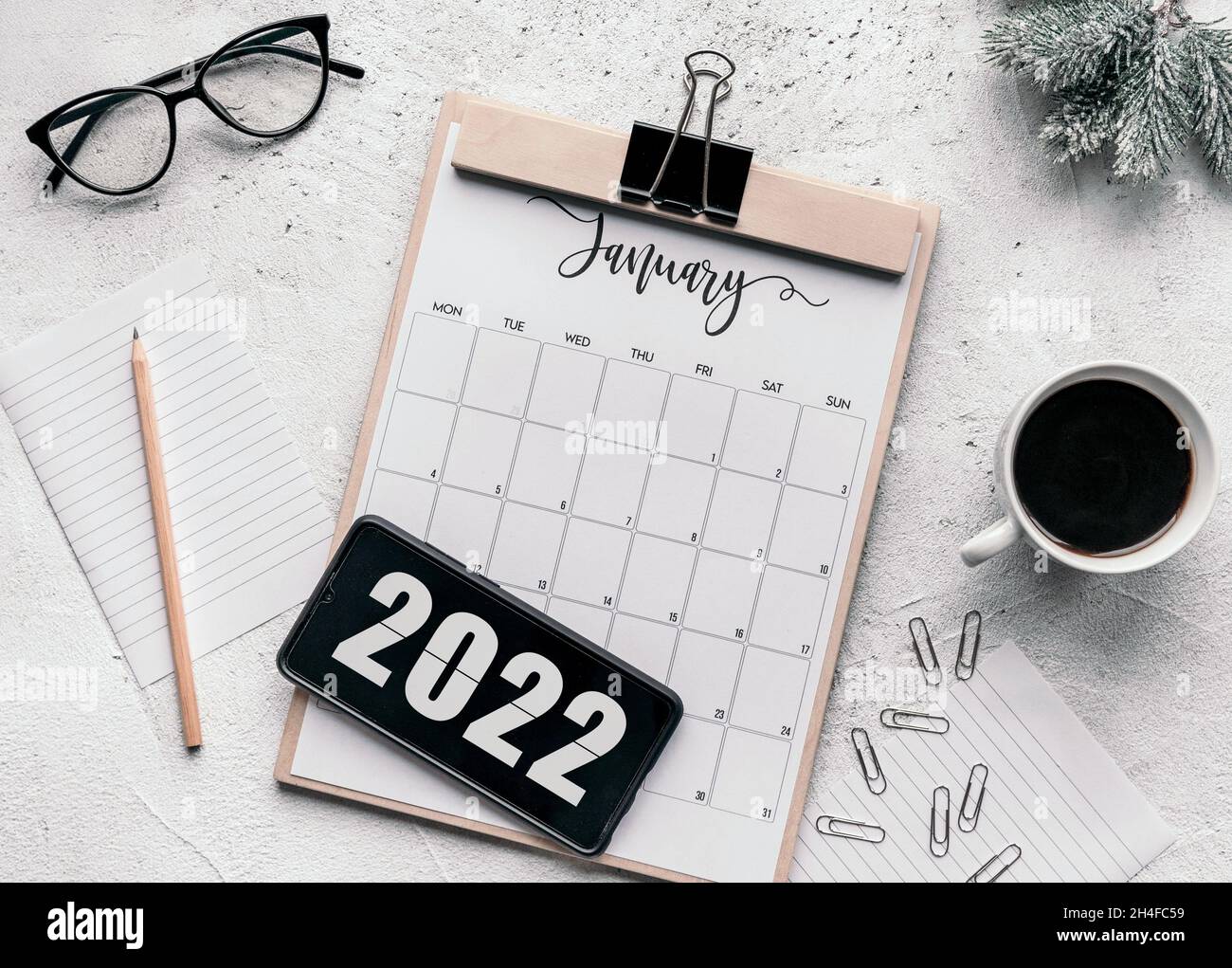 Januar Kalender flach lag. Draufsicht des Januarkalenders auf der Tabelle und des Jahres 2022 auf dem Display des Mobiltelefons. Stockfoto