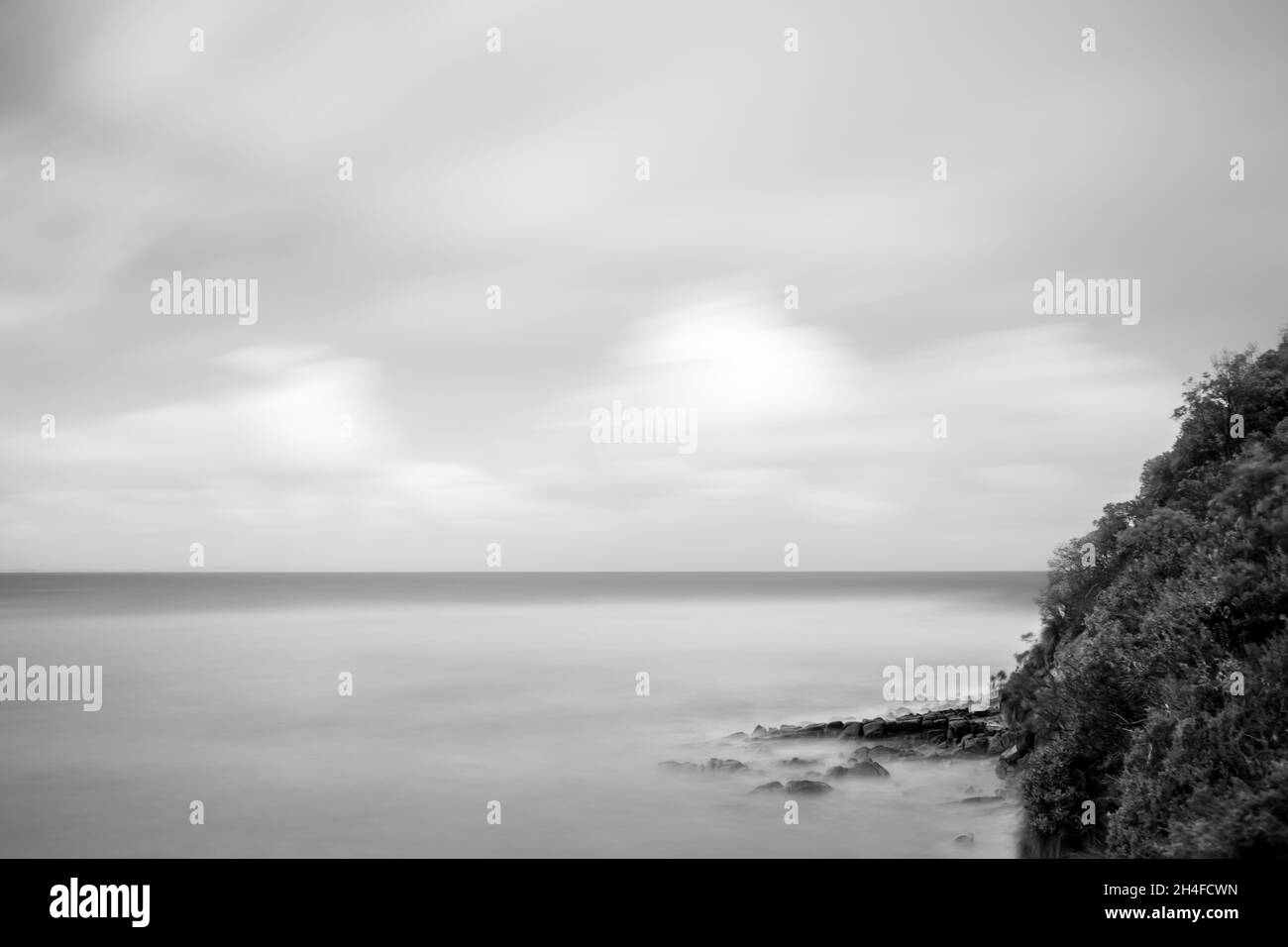 Schwarz-Weiß-Langzeitbelichtung eines felsigen australischen Strandes Stockfoto