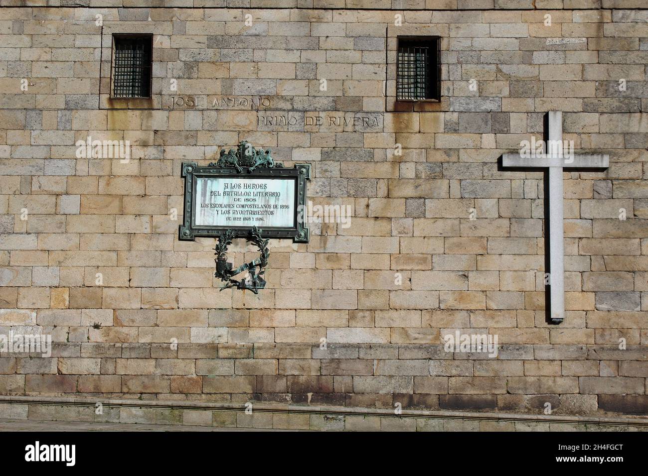 Großes weißes Kreuz und Schrifttafel an einer Wand auf der Praza da Quintana de Vivos, Quintana de Mortos, Santiago de Compostela, Galicien, Spanien. Stockfoto