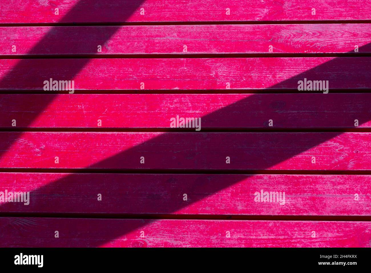 Fuchsia Holzboden mit diagonalen Schatten, Staub und Sandrückständen. Realistisches Foto. Stockfoto