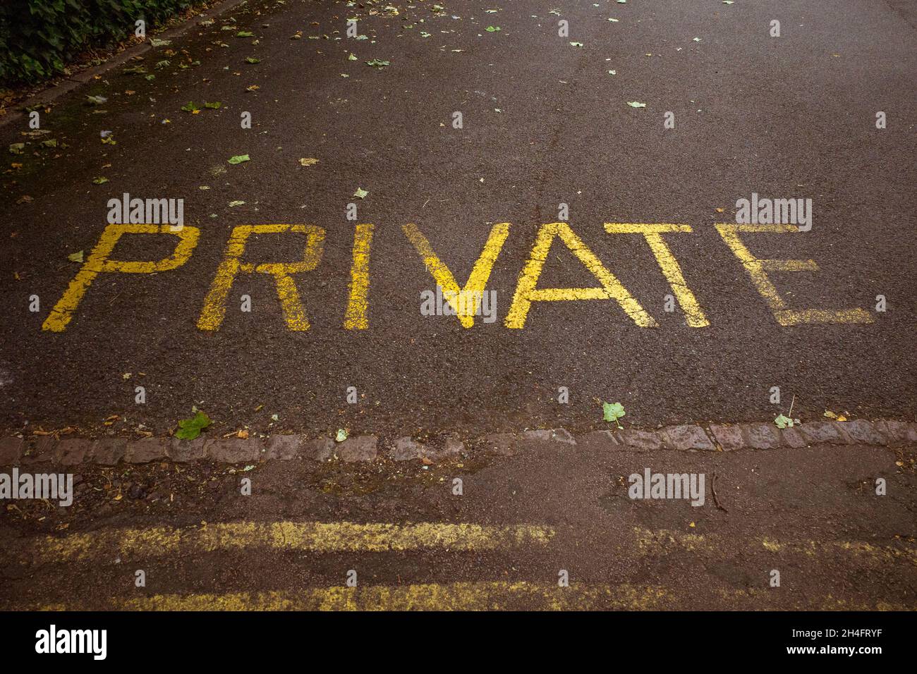 Das Wort privat malte auf eine Straße in gelber Farbe. Stockfoto