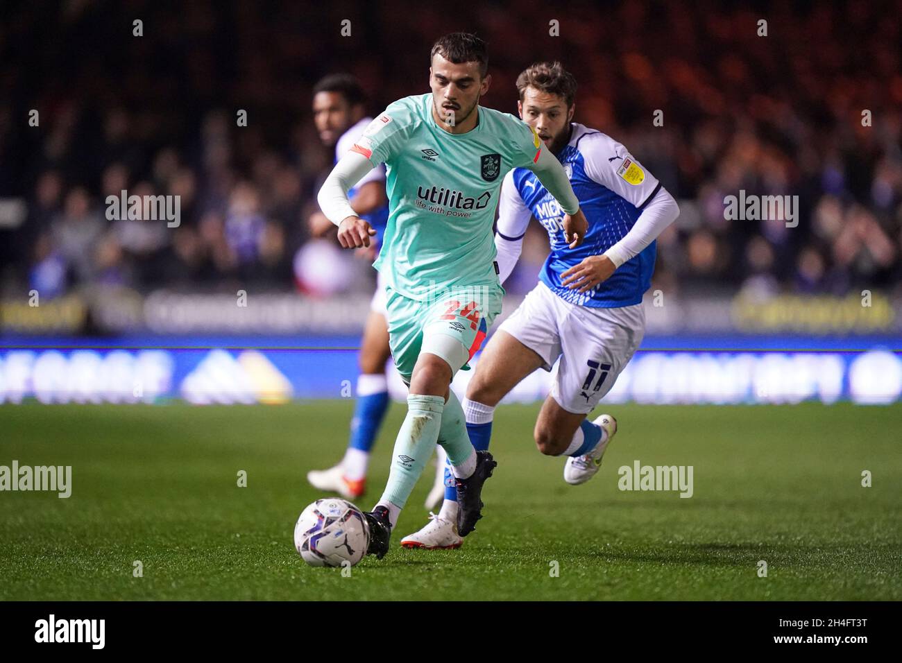 Danel Sinani von Huddersfield Town (links) und Jorge Grant von Peterborough United (rechts) kämpfen während des Sky Bet Championship-Spiels im Weston Homes Stadium, Peterborough, um den Ball. Bilddatum: Dienstag, 2. November 2021. Stockfoto