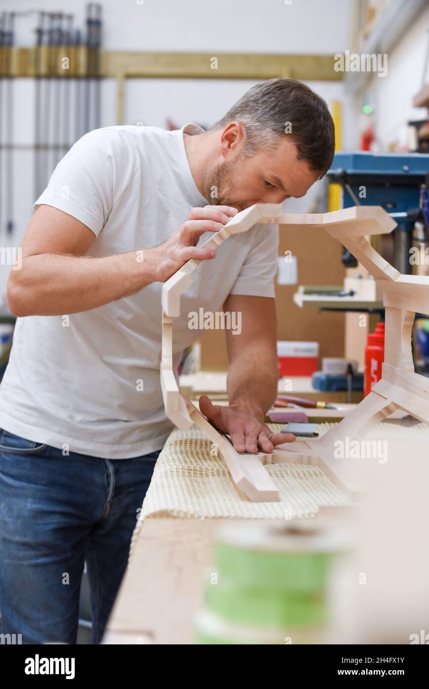 Mann, der als Tischler in einer Holzwerkstatt Möbel macht Stockfoto