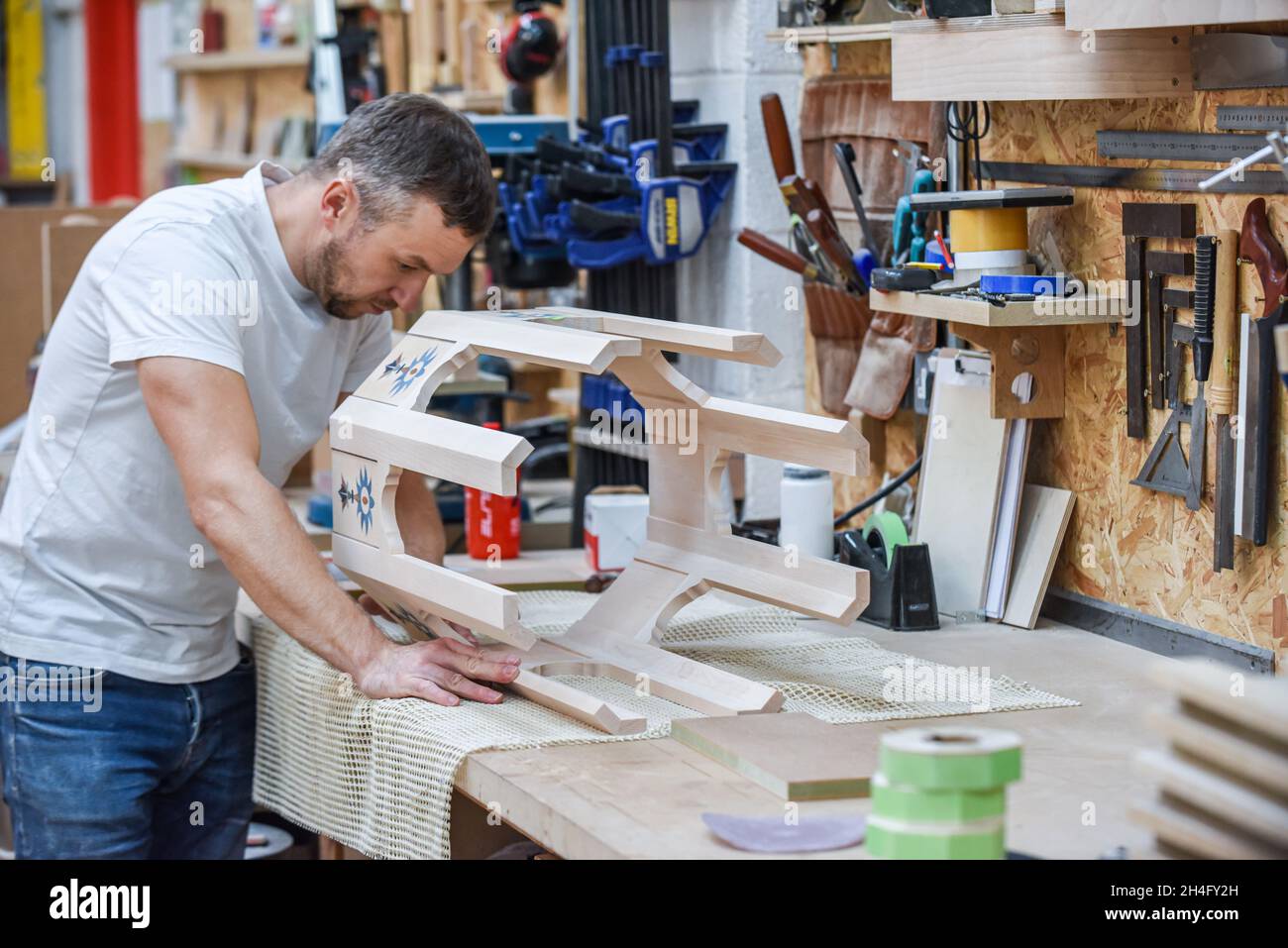 Mann, der als Tischler in einer Holzwerkstatt Möbel macht Stockfoto