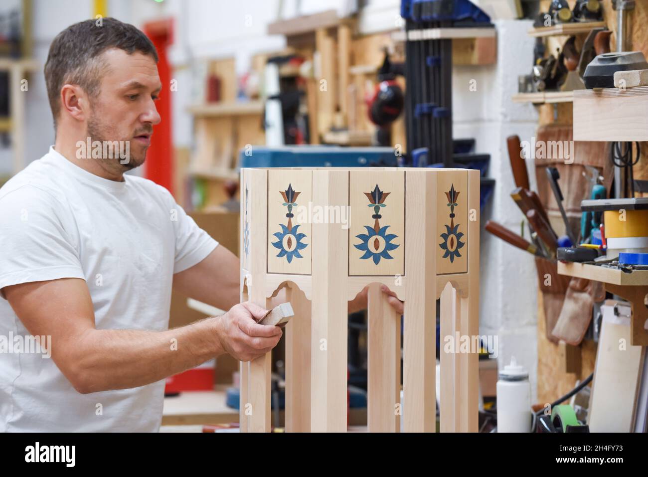 Mann, der als Tischler in einer Holzwerkstatt Möbel macht Stockfoto