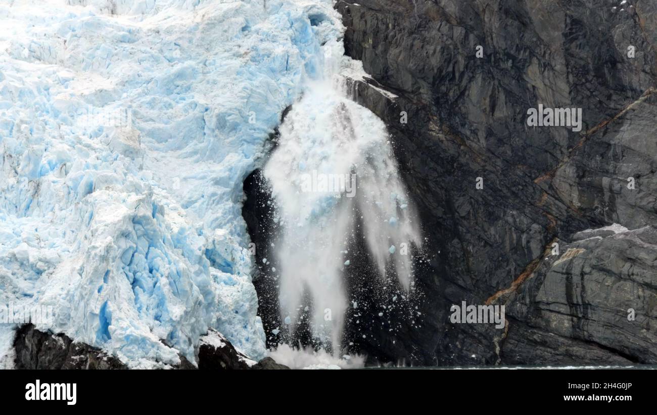 Vorderansicht eines Gletschereisbrockens, das aufgrund der Auswirkungen des Klimawandels abbricht und ins Meer fällt. Stockfoto