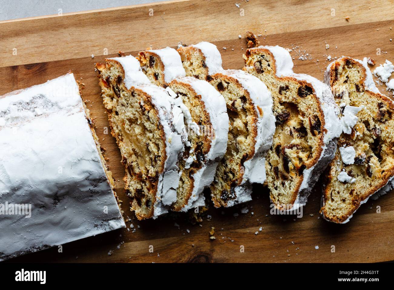 Direkt über Schuss Marzipan Stollenkuchen mit Puderzucker, in Scheiben geschnitten Stockfoto