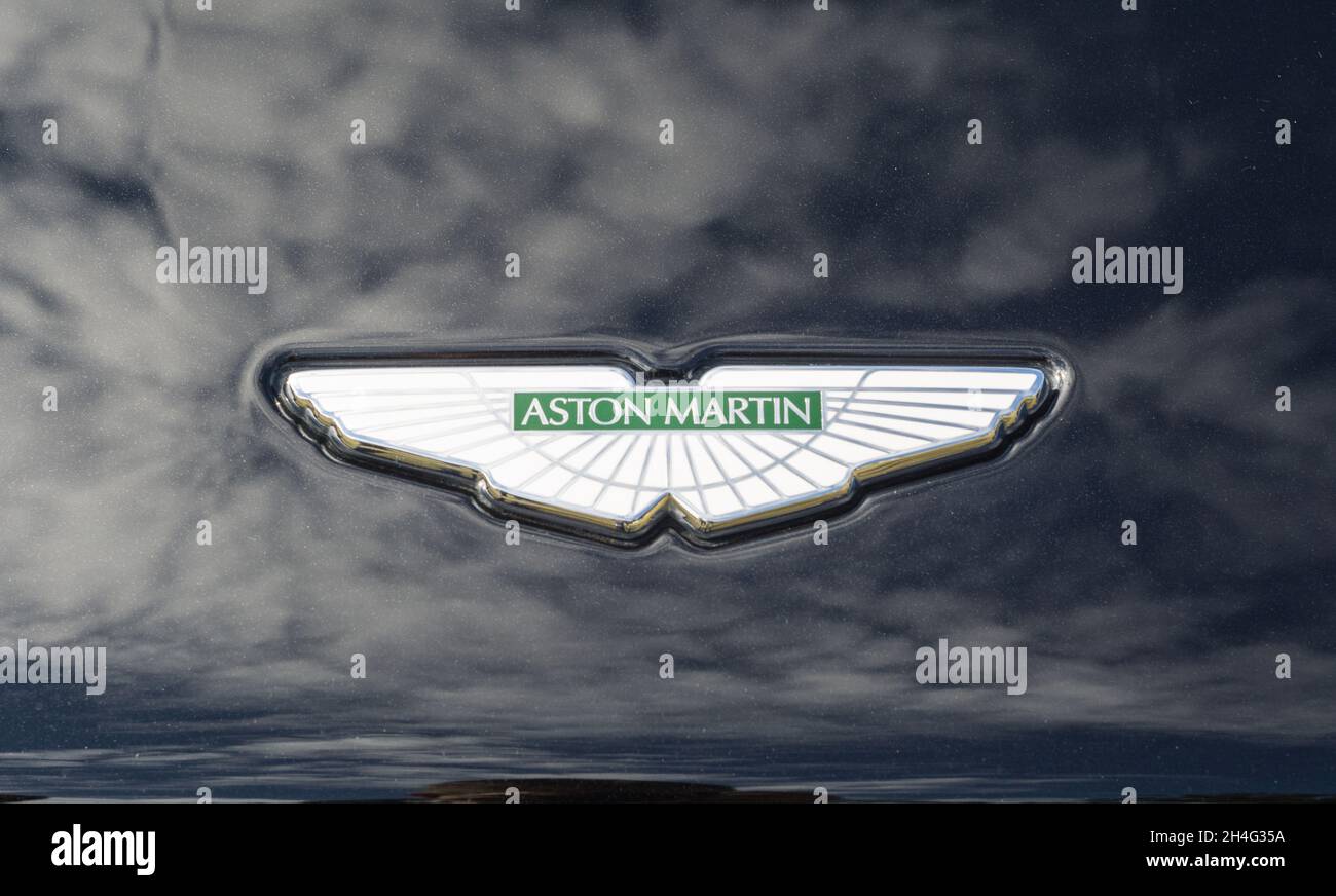 Nahaufnahme des Namensemblems des Aston Martin-Logos auf der Motorhaube eines schwarzen DBS-Sportwagens Stockfoto