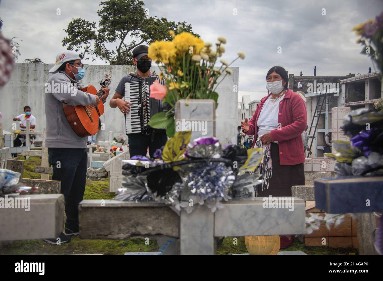 Ecuador. November 2021. Una mujer dedica una serenata para sus difuntos. QUITO-ECUADOR, 2. November 2021. Nach zwei Jahren, in denen die Menschen die Friedhöfe Ecuadors nicht besucht haben, haben die Menschen diese Tradition wieder aufgenommen, in großer Zahl besuchten die Bewohner der Gemeinde Calderon in Quito ihren Verstorbenen auf dem zentralen Friedhof, der den gleichen Namen der Pfarrei trägt. (Foto: Juan Diego Montenegro/Sipa USA) Quelle: SIPA USA/Alamy Live News Stockfoto