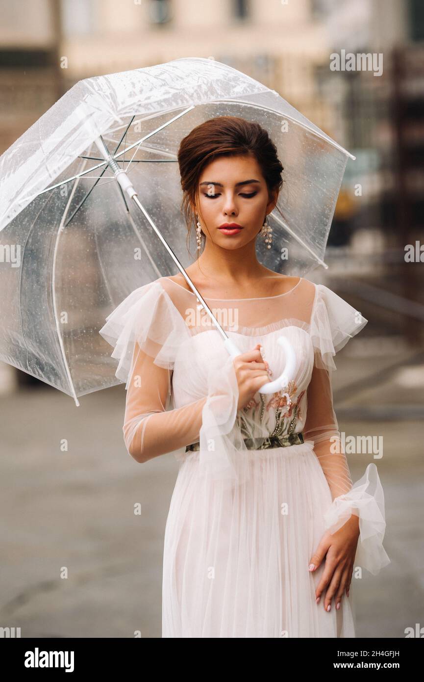 Eine schöne stilvolle Braut mit einem Regenschirm geht durch die Altstadt von Florenz.Modell mit Regenschirmen in Italien.Toskana Stockfoto