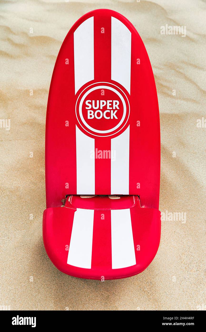 Rot-weißer Strandstuhl im Sand, Werbung für portugiesisches Bier mit Logo  Super Buck, Algarve, Portugal Stockfotografie - Alamy