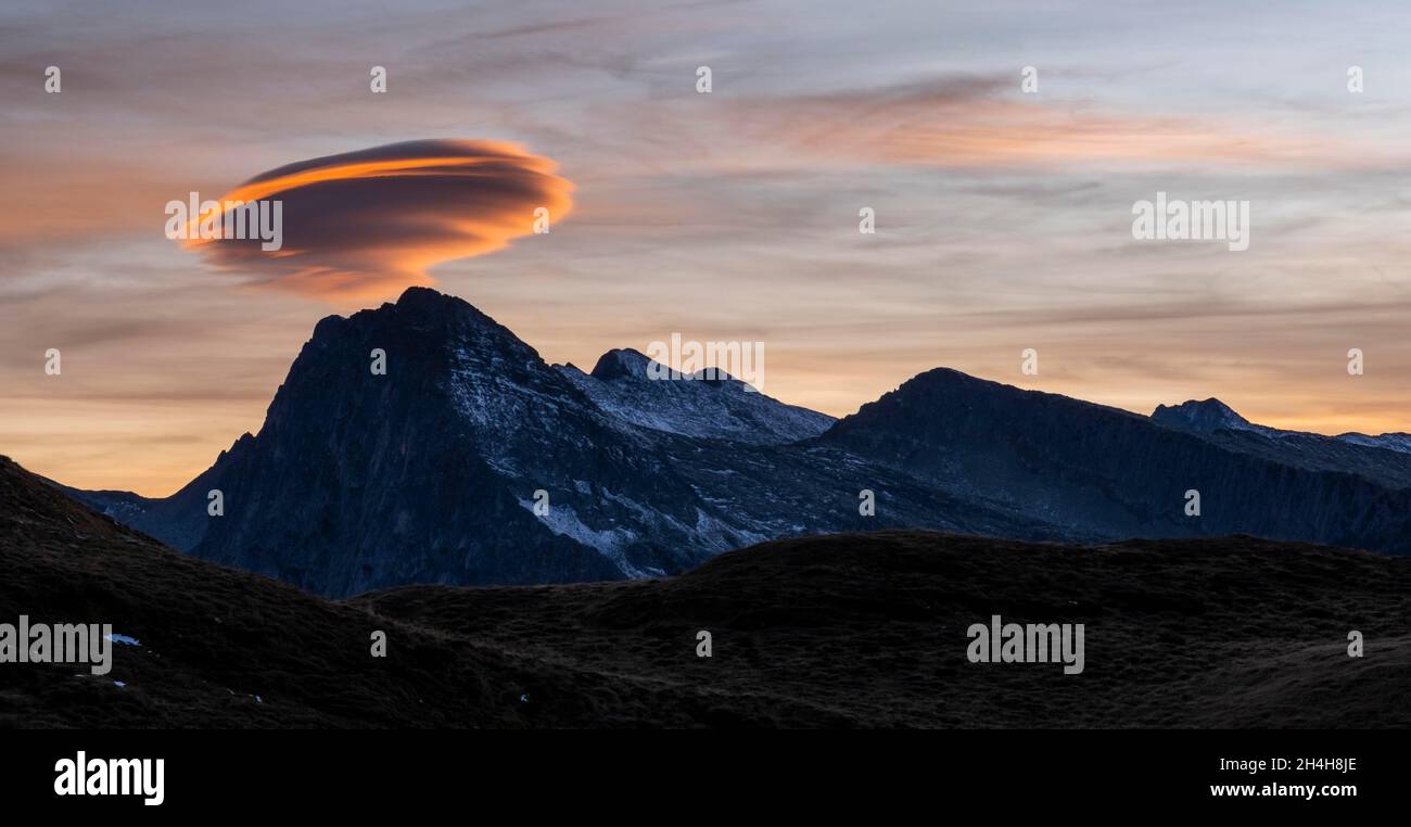 Lenticularis-Wolke über der Lagorai-Bergkette, Sonnenuntergang, Parco Naturale Paneveggio Pale di San Martino, Rollepass, Trentino, Italien Stockfoto