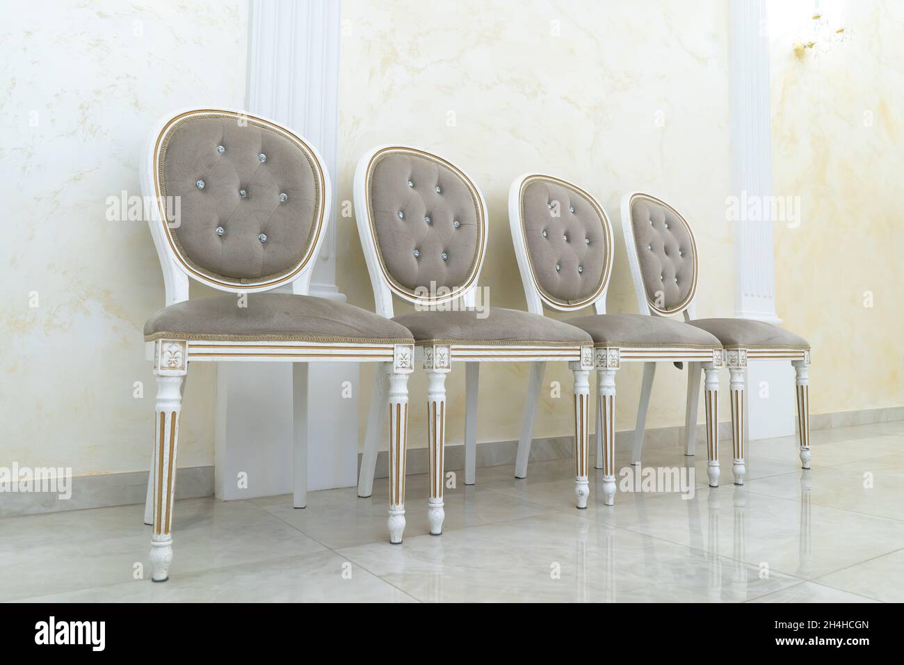 4 Vintage-Sessel stehen auf dem Boden in der Halle. Stockfoto