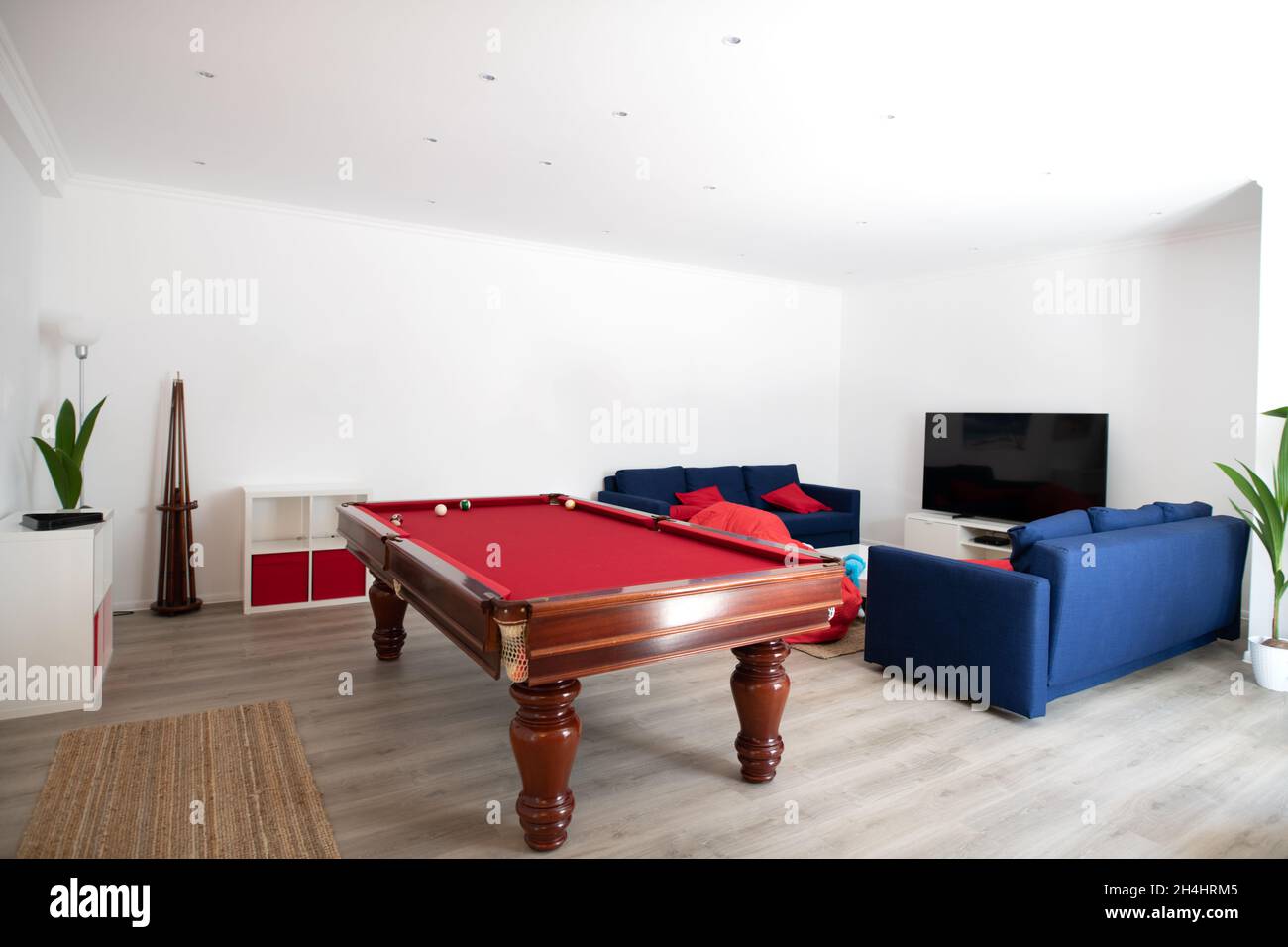 Wohnzimmer mit Billardtisch und blauen Sofas Stockfoto