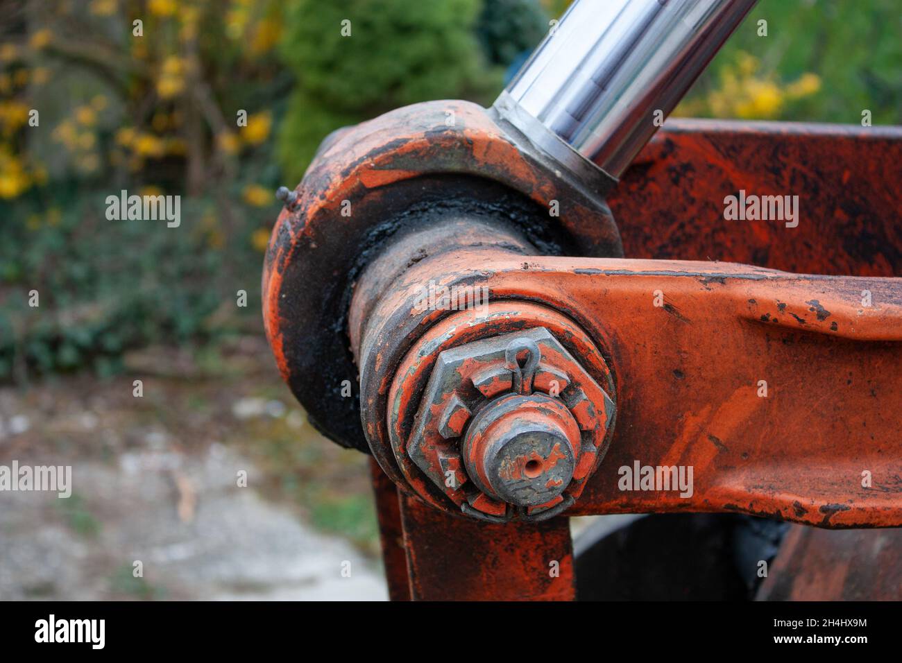 Nahaufnahme des Hydrauliksystems mit orangefarbenem Baggerausleger Stockfoto