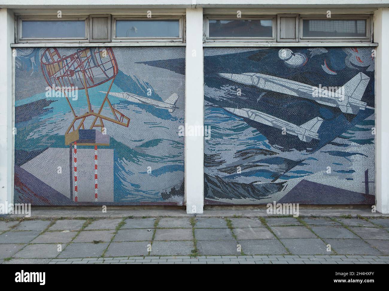 Sowjetische Kampfflugzeuge, dargestellt im Wandmosaik am Rechenzentrum Potsdam (RZ) in Potsdam. Das Gebäude des ehemaligen sozialistischen Rechenzentrums ist mit den Mosaiken des deutschen Künstlers Fritz Eisel (1971-1972) mit dem Titel 'der Mensch erobert den Kosmos' bedeckt. In diesem Teil des Mosaiks sind sowjetische Kampfflugzeuge MiG-23 oder MiG-25 abgebildet. Stockfoto