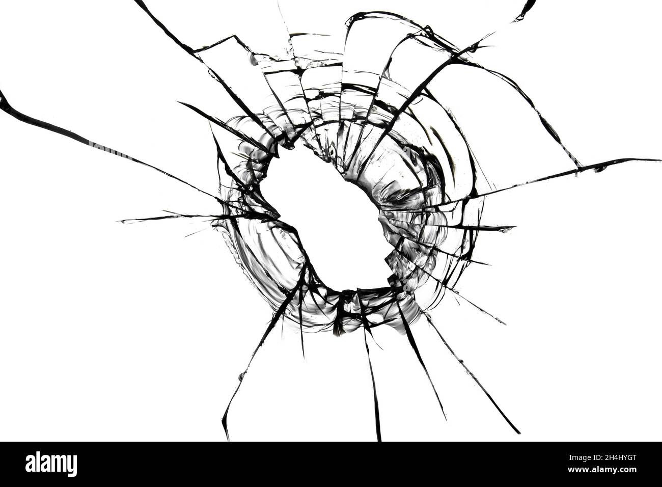 Risse aus einer Kugel im Glas. Zerbrochenes Glas. Abstrakte Textur auf weißem Hintergrund Stockfoto