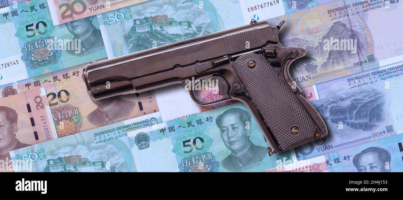 Chinesisches Verbrechen und Korruption, schmutziges Geldkonzept. Pistole auf China Yuan Renminbi Geldscheine Hintergrund. Stockfoto