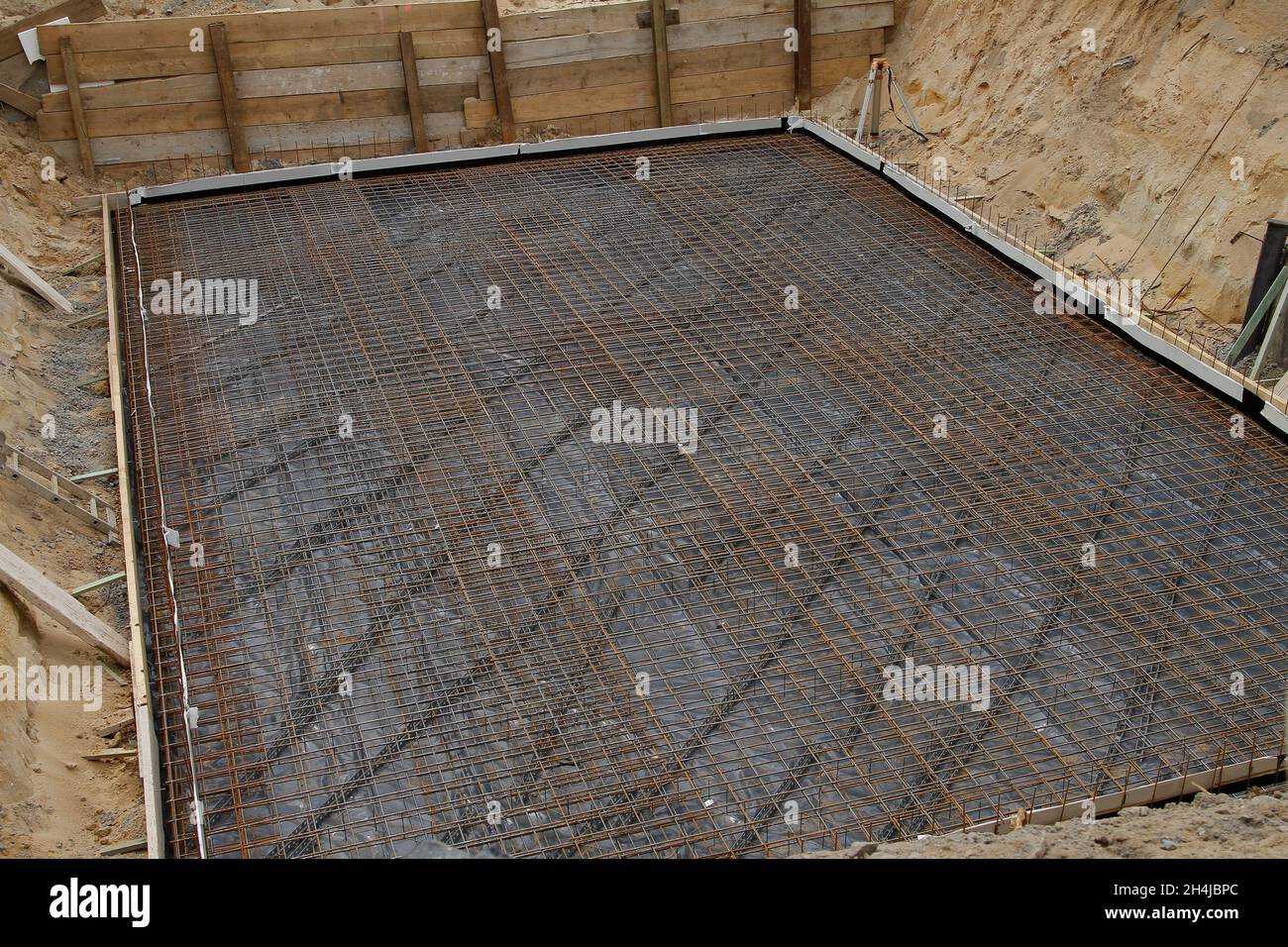 Verstärkender Stahl, der bereit ist, in einer ausgegrabenen Grube mit Beton zu bedecken Stockfoto