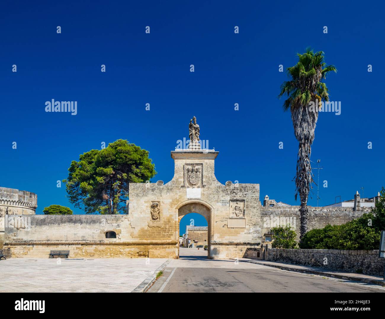 Das kleine befestigte Dorf Acaya, Lecce, Salento, Apulien, Italien. Der große gepflasterter Platz. Das Tor zur Stadt, mit dem großen Bogen und Th Stockfoto
