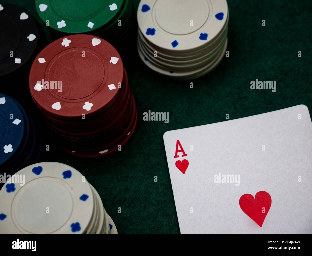 Poker-Spieltisch, einzelne Ass-Karte mit Stapel von Spielchips Stockfoto