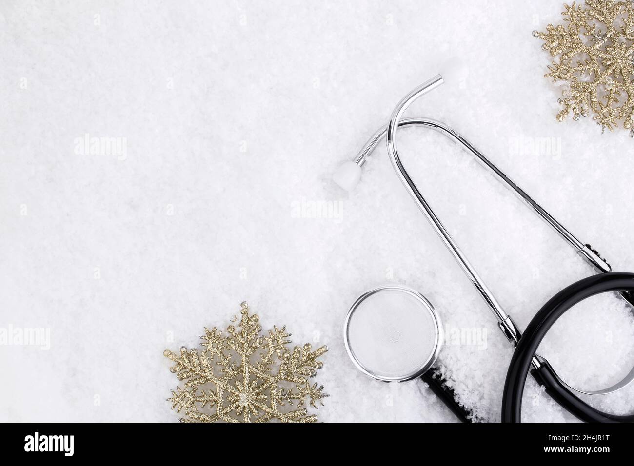 Medizinisches Stethoskop auf einem verschneiten Hintergrund in der Nähe von Schneeflocken. Medizinisches Konzept für Weihnachten oder Neujahr. Flach. Speicherplatz kopieren Stockfoto